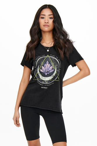 Zwart T-shirt van ONLY met een grafische print van een lotusbloem en een halve maan, gecombineerd met zwarte fietsbroeken.
