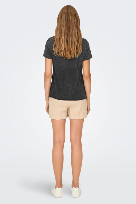 Zwart T-shirt met korte mouwen van ONLY, gezien van achteren, met casual beige katoenen shorts en witte schoenen.
