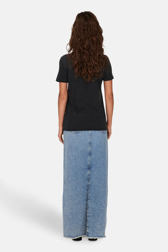 Zwart T-shirt van ONLY, met korte mouwen, gedragen met een lange jeans rok.