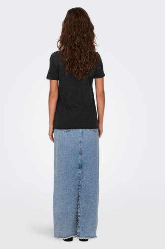 Zwart T-shirt van ONLY, met korte mouwen, gedragen met een lange denim rok.
