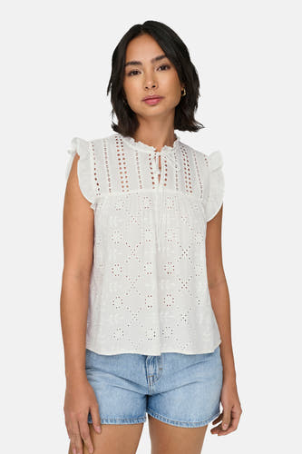 Witte mouwloze blouse van ONLY, met broderie details en koordjes aan de hals, gecombineerd met denim shorts.
