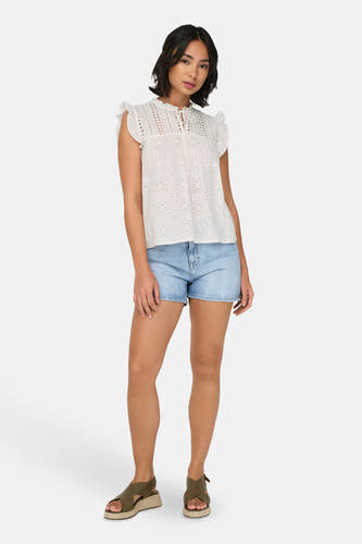 Witte mouwloze blouse van ONLY, met kanten details en gecombineerd met denim shorts en sandalen.
