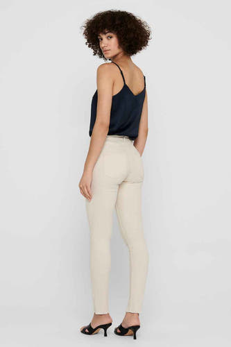 Jean skinny beige de ONLY, vu de l'rière combin combiné avec un top bleu marine et des baskets noires.