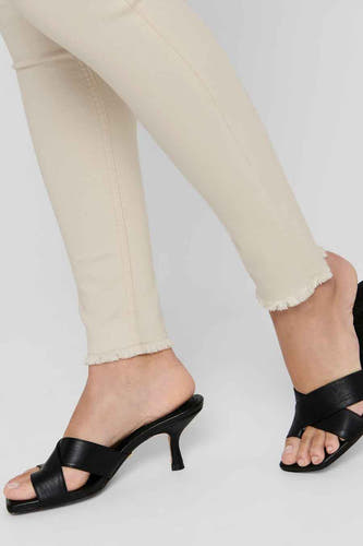 Jean skinny beige de ONLY, avec un bord froncé et associé à des bottes noires.