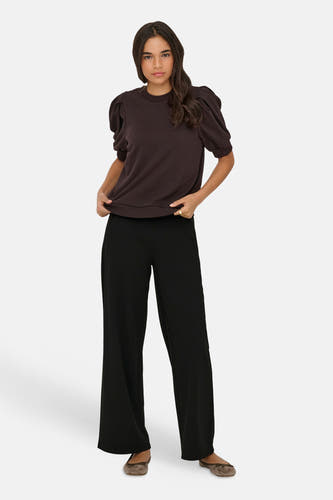 Pantalon de costume noir ample de JDY, porté par un mannequin avec un pull marron foncé et des ballerines.