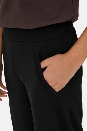 Pantalon de costume noir de JDY avec poche latérale insérée et une main dedans.