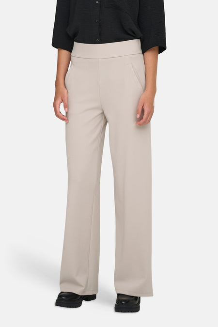 Lichtgrijze kostuumbroek van JDY met hoge taille en wijde pijpen, gedragen met zwarte blouse en loafers.