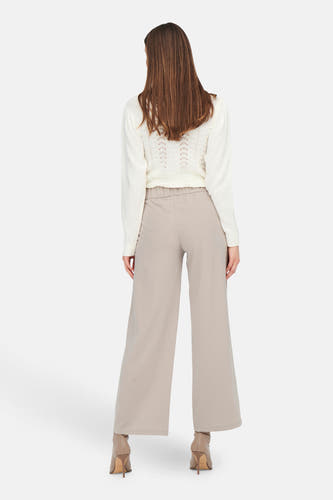 Pantalon gris de costume JDY, avec des jambes larges et associé à une chemise blanche et des mocassins beige.