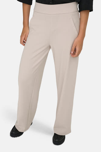 Pantalon de costume beige clair de JDY avec taille haute, jambes larges et poches italiennes, stylisé avec des mocassins noirs.