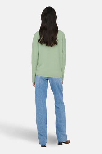 Groene V-halstrui van ONLY, gedragen met een blauwe jeans en bruine hakken, rugzijde.
