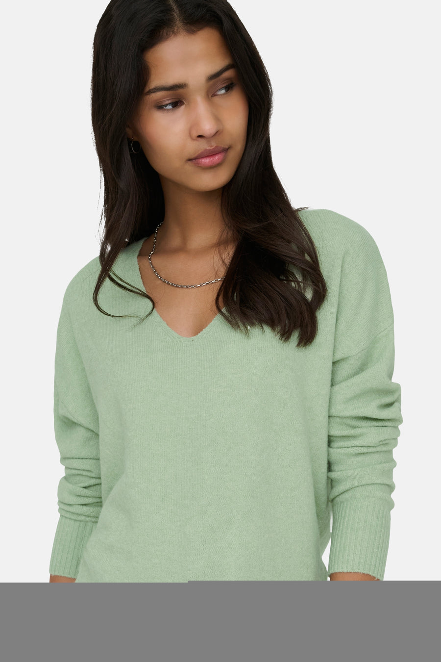 Groene trui met V-hals van ONLY, met een zilverkleurige ketting.