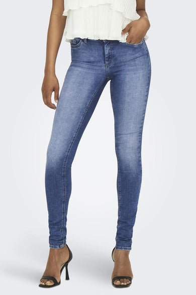 Skinny jeans in blauw denim van ONLY, gecombineerd met een witte top en hakken met bandjes.
