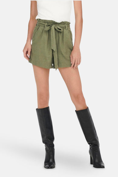 Short vert de JDY, avec une poche en papier et une ceinture assortie, porté avec des bottes noires.