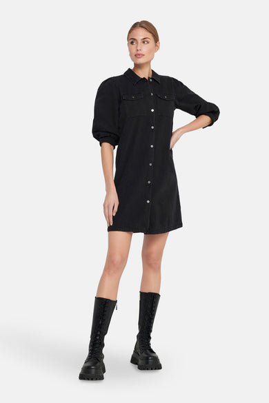 Korte denim jurk van ONLY, met lange mouwen en zwarte laarzen.
