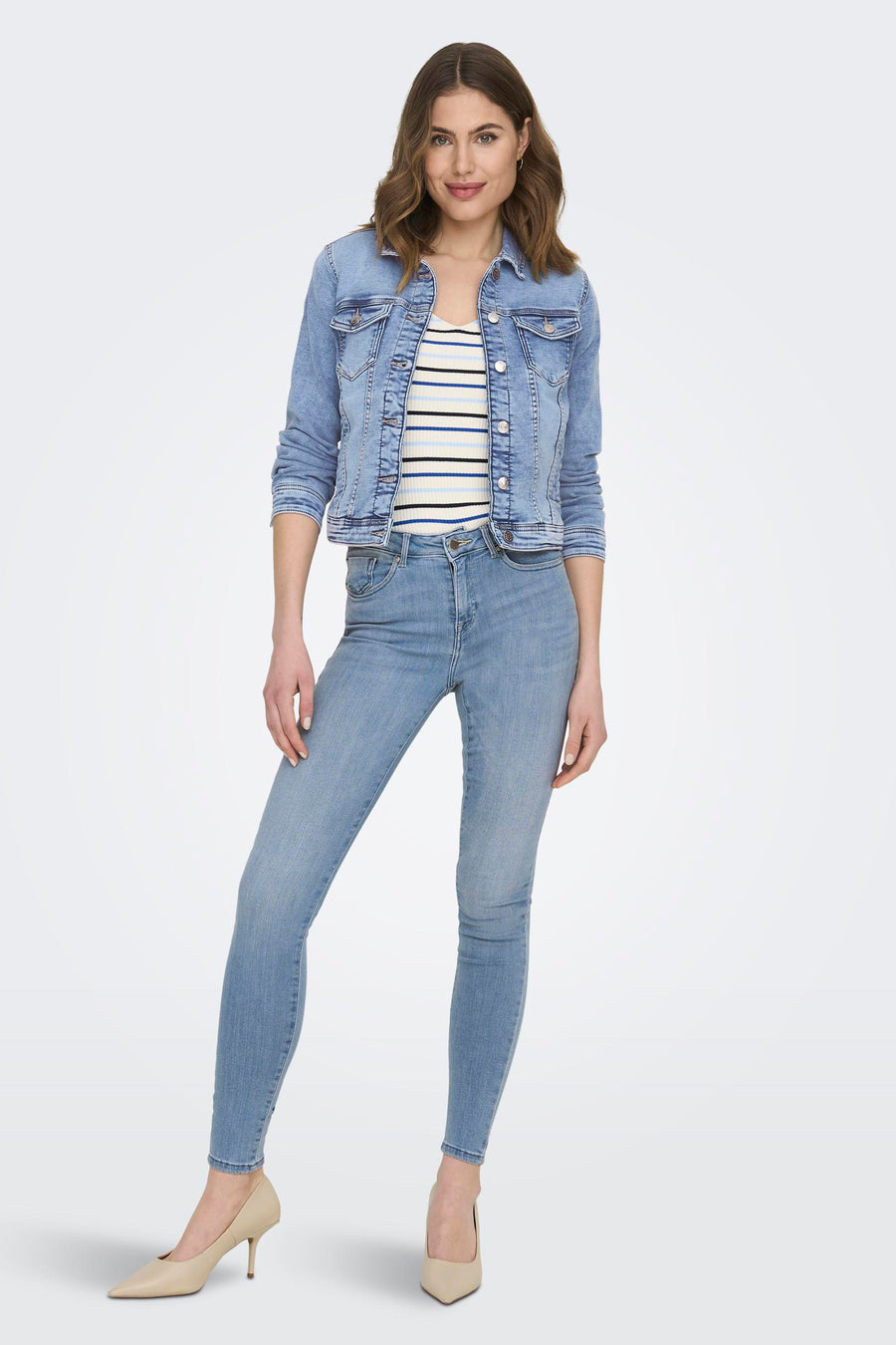 Lichtblauwe skinny jeans van ONLY, gecombineerd met een gestreepte top en spijkerjasje, met beige pumps.
