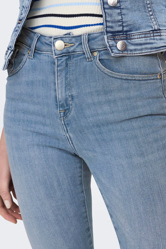 Jean skinny bleu clair d'ONLY, avec fermeture à boutons et un blouson en denim avec une chemise rayée.