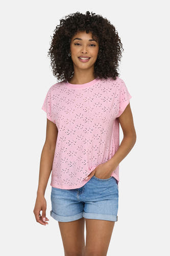 T-shirt rose à manches courtes ONLY, avec un motif ajouré. La dame porte un short en jean et des tongs.
