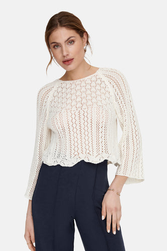 Ecru trui met ronde hals van ONLY, opengebreide textuur, gedragen met een donkerblauwe broek.
