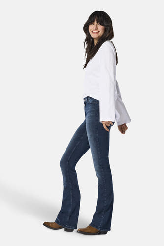Jean flare bleu marine d'ONLY, avec un haut à manches longues et des bottes brunes.