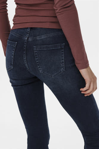 Jeanon flare bleu denim ONLY, avec des poches arrière, associé à une chemise bordeaux.