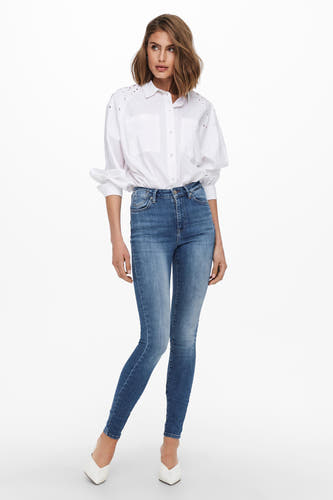 Skinny jeans van mid blue denim van ONLY, gecombineerd met een wit shirt en witte schoenen.