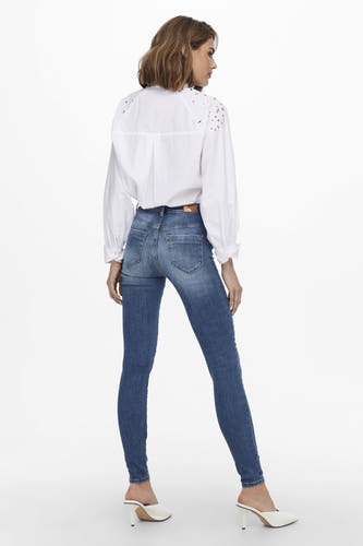 Blauwe skinny jeans van ONLY, met een klassieke wassing en gecombineerd met een witte blouse.
