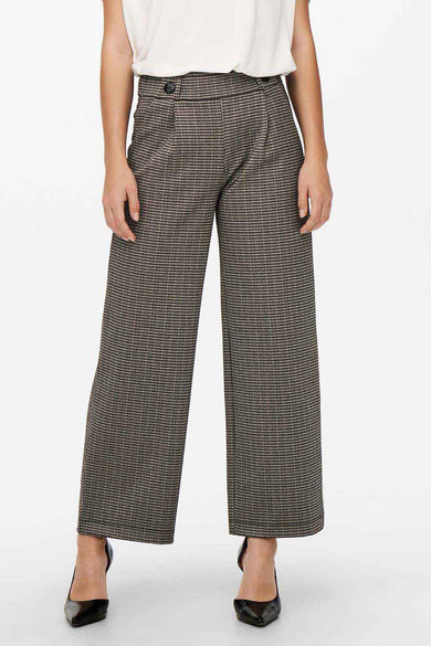 Grijze broek van JDY met een ruitpatroon en een wijde pijp, gecombineerd met zwarte pumps.

