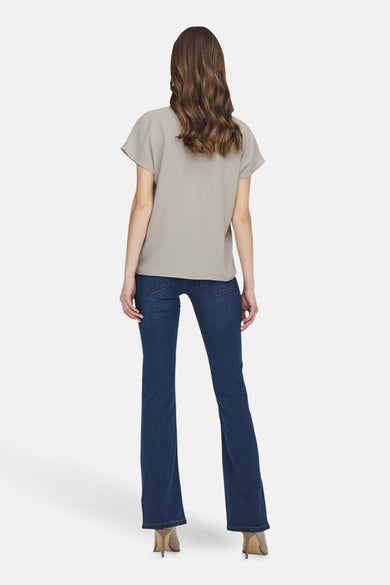 Beige blouse met korte mouwen van JDY, achterkant, gecombineerd met donkere jeans en hakken.