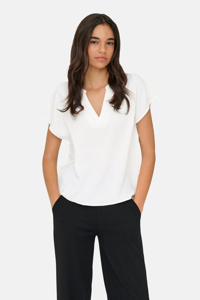 Witte blouse van JDY met V-hals, korte wijdvallende mouwen en een gestructureerde stof, gedragen met een zwarte broek.