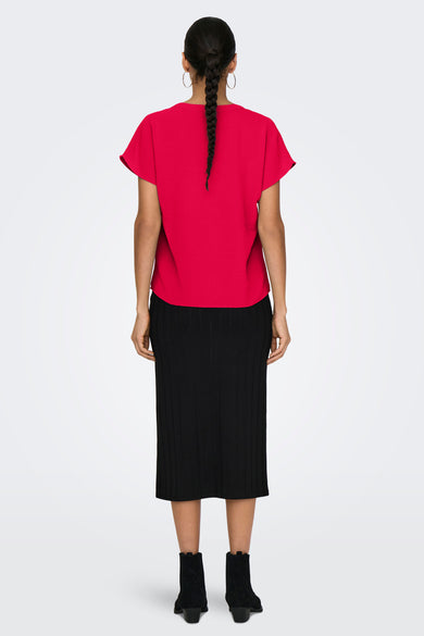 Blouse rouge à manches courtes de JDY, avec une subtile texture, portée avec une jupe noire et des bottines.