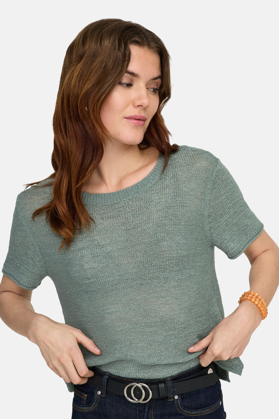 Pull vert de ONLY®, à manches courtes, porté avec un jean et une ceinture.