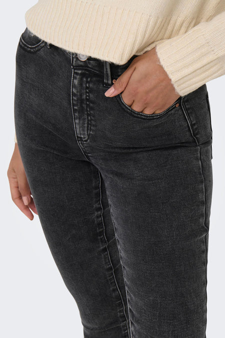 Donkergrijze skinny jeans van ONLY® met subtiele verbleekdetails, strakke pasvorm en zichtbare zakken, gedragen met een crèmekleurige trui.