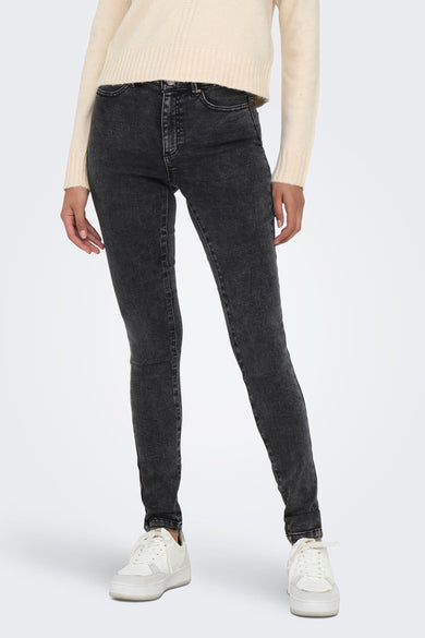 Donkergrijze skinny jeans van ONLY®, met subtiele verbleekdetails, strakke pasvorm en klassieke vijfzakkenstijl, gedragen met crèmekleurige trui en witte sneakers.
