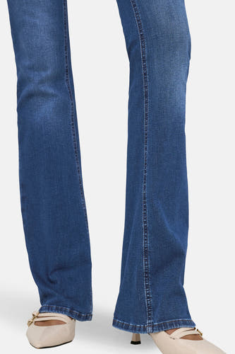 Jean flared bleu foncé d'ONLY, avec des coutures et combiné avec des chaussures beige à bout pointu.