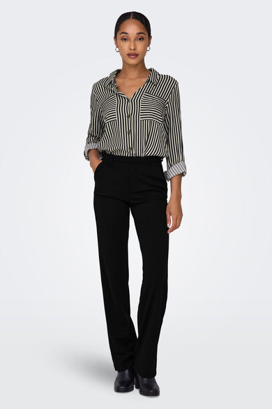 Zwarte damesbroek van ONLY, met een gestreepte blouse en zwarte laarzen.
