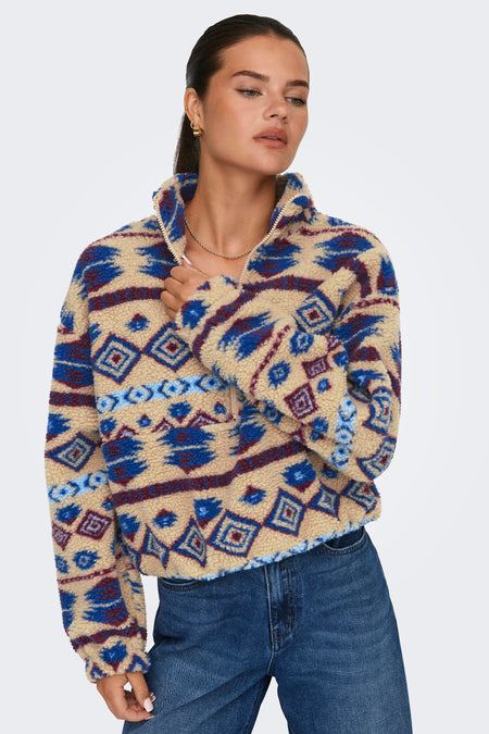 Beige fleece van ONLY met een grafisch patroon en een korte ritssluiting, gedragen met een jeans.
