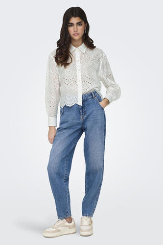 Blouse blanche à manches longues de ONLY, ornée de détails ajourés et portée avec des jeans bleus et des baskets.