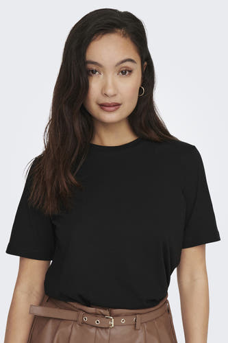 T-shirt noir ONLY, manches courtes, porté avec un pantalon marron et des boucles d'oreilles en or.