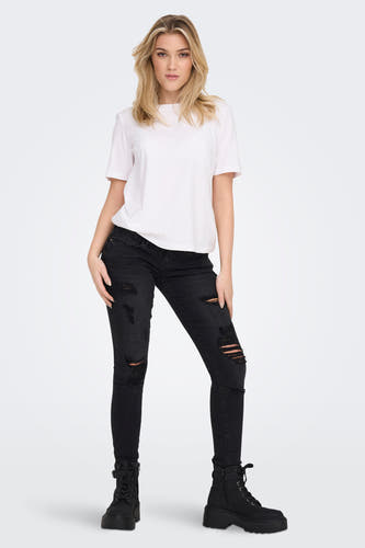 T-shirt blanc ONLY®, porté avec un jean noir déchiré et des bottes noires.