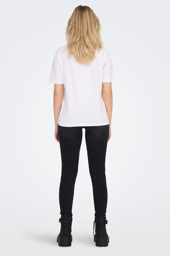 T-shirt blanc ONLY, manches courtes, porté avec un jean noir et des bottes noires, vu de dos.