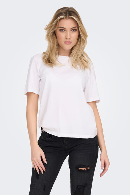 Wit T-shirt met korte mouwen van ONLY, gedragen met een zwarte jeans met gaten.
