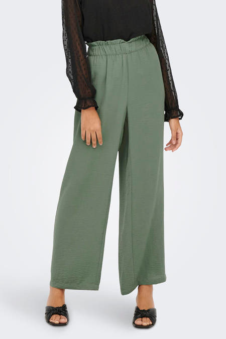 Kaki broek van JDY met wijde pijpen en een elastische tailleband, gecombineerd met een zwarte blouse.
