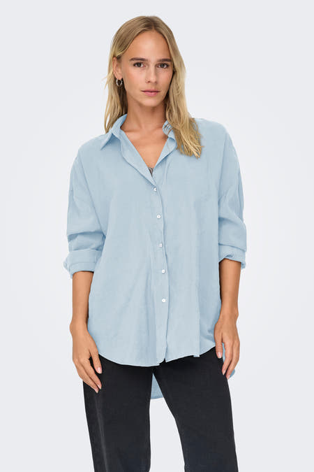 Blauw hemd met lange mouwen van ONLY, losvallend model gedragen met zwarte jeans en zilveren oorbellen.