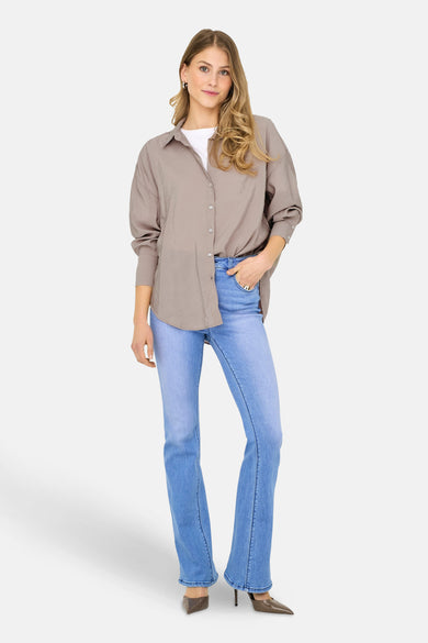 Beige hemd met lange mouwen van ONLY, gedragen met een wit T-shirt en blauwe jeans.