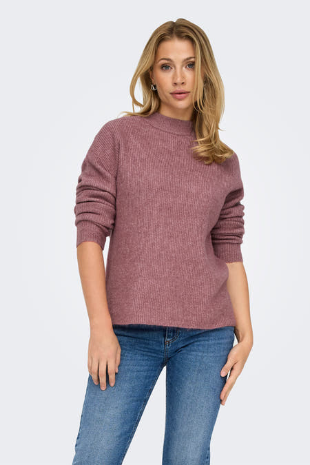 Roze trui met ronde hals van ONLY, met lange mouwen en geribbelde textuur, gecombineerd met een jeans.
