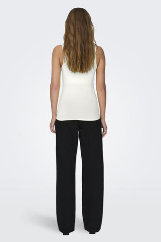 Débardeur écru avec bretelles spaghetti de la marque ONLY, porté avec un pantalon noir, vue de dos.