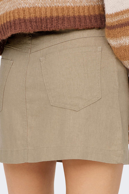 Beige korte rok van ONLY® met zakken, achterzijde close-up, gestructureerd materiaal, model draagt gebreide trui