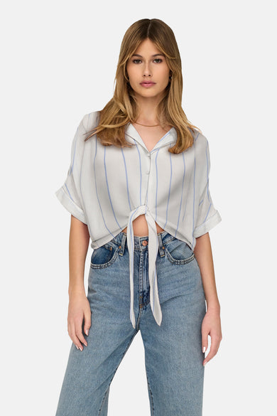 Wit hemd met korte mouwen van ONLY, met blauwe strepen en geknoopt aan de voorkant, gedragen met een jeans.
