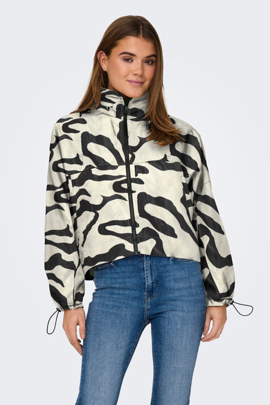 Witte jas van ONLY met zwart zebrapatroon, gecombineerd met een blauwe jeans.
