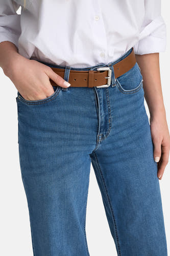Jean large en denim bleu moyen d'ONLY, avec ceinture marron et un blouse blanche.